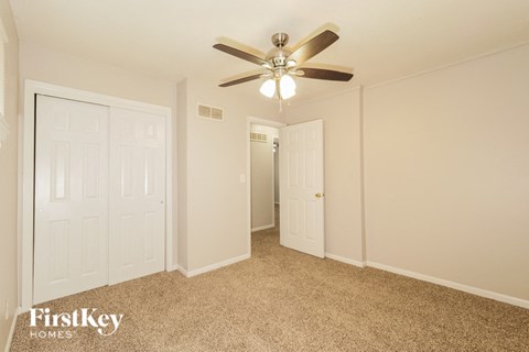 a bedroom with a ceiling fan and a closet