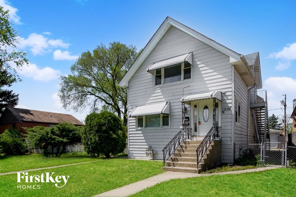 A two-story house with a porch and a staircase leading to the second floor.