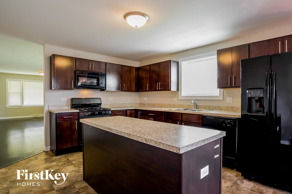 A kitchen with dark brown cabinets and a countertop.