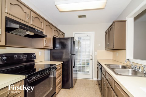 a kitchen with stainless steel appliances and a black refrigerator