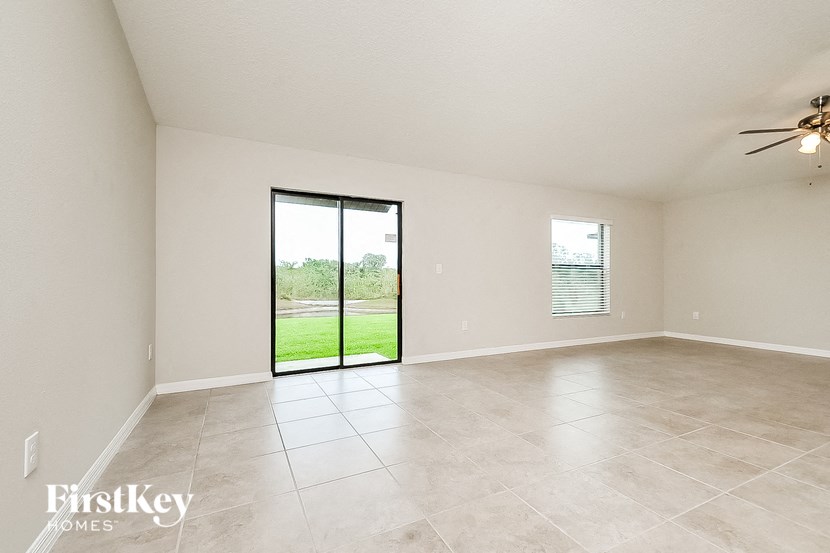 an empty living room with a sliding glass door to the yard