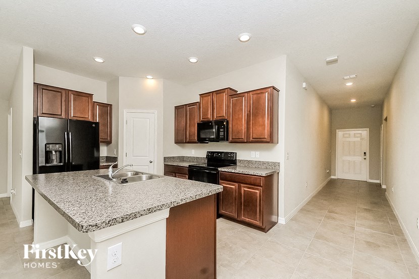 a kitchen with granite counter tops and wooden cabinets
