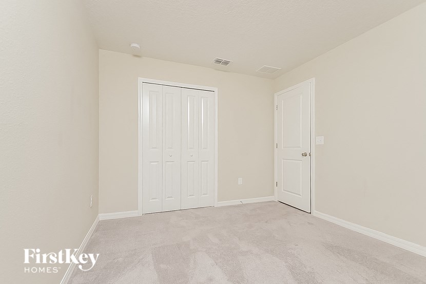 a bedroom with two doors and a carpeted floor