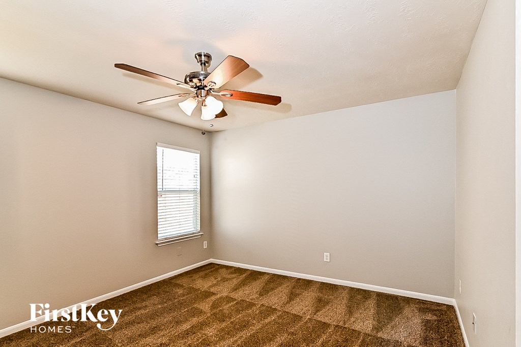 a bedroom with a ceiling fan and a window