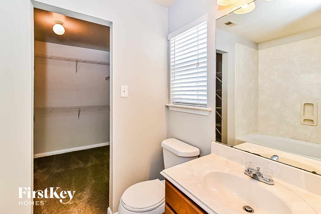 a bathroom with a toilet and a sink and a mirror