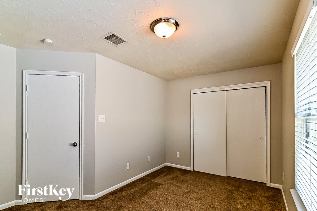 a bedroom with two closets and a window