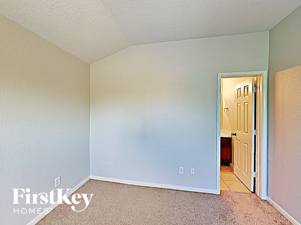 the master bedroom has a door to the hallway and carpeted flooring