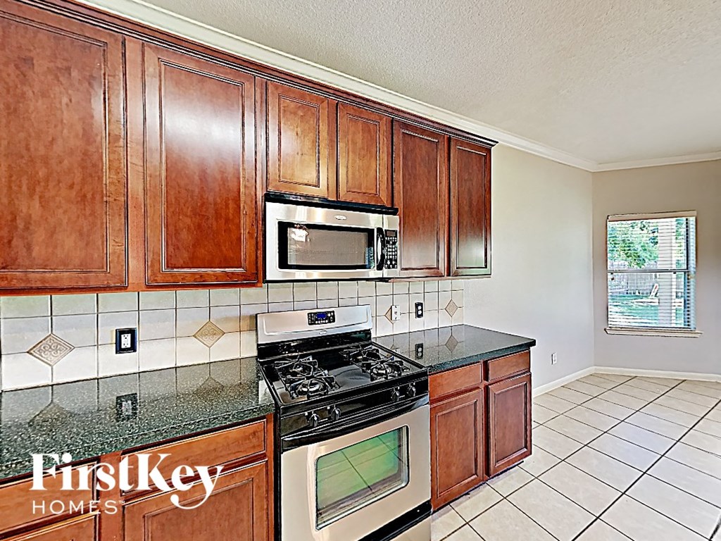 a kitchen with a stove and a microwave and wooden cabinets
