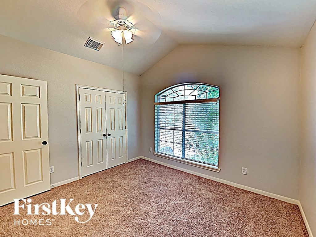 an empty bedroom with a large window and a closet