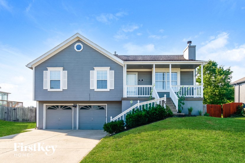 a blue house with a garage and a lawn