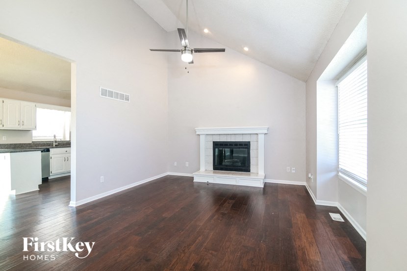 a living room with a fireplace and wooden floors