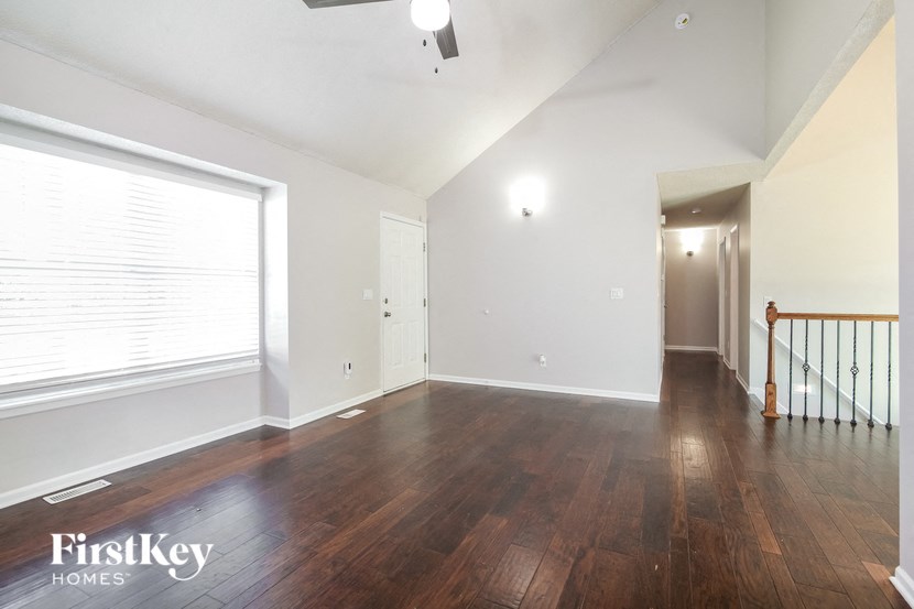 an empty living room with wood floors and a large window