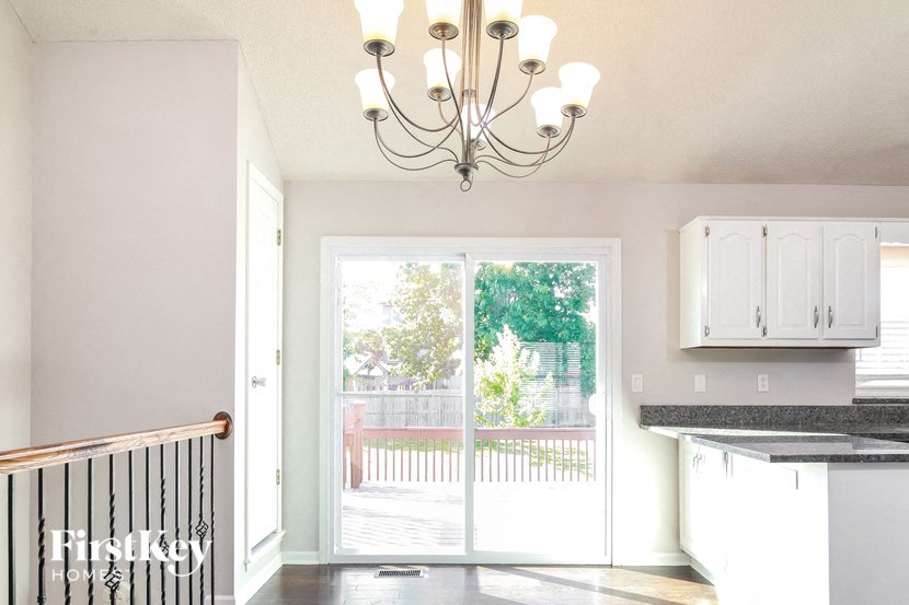 a kitchen with a chandelier and a door to a patio