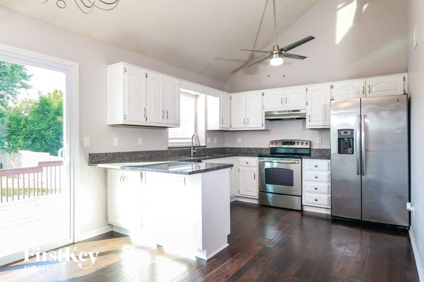 a kitchen with white cabinets and stainless steel appliances