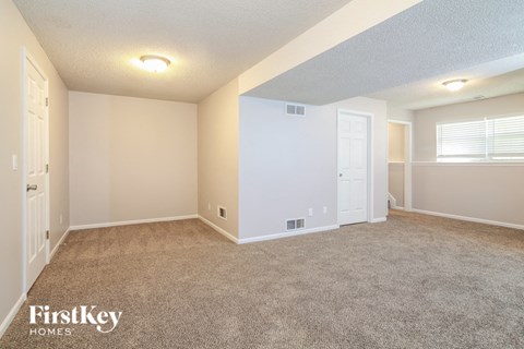 the living room of a home with carpet and a white door