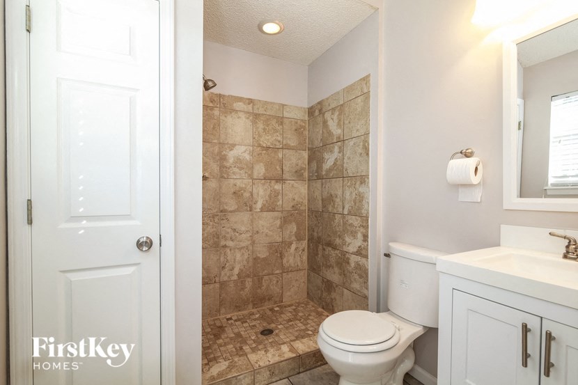 a bathroom with a toilet and a shower and a sink