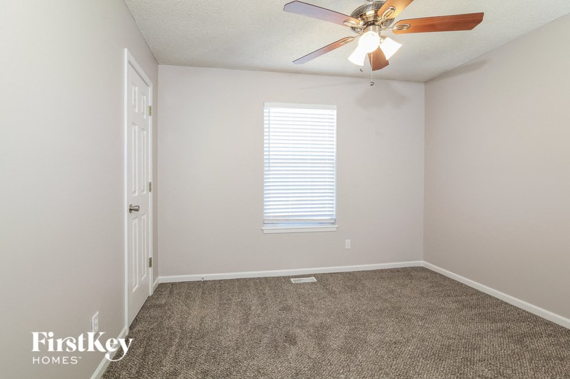 an empty room with a ceiling fan and a white door