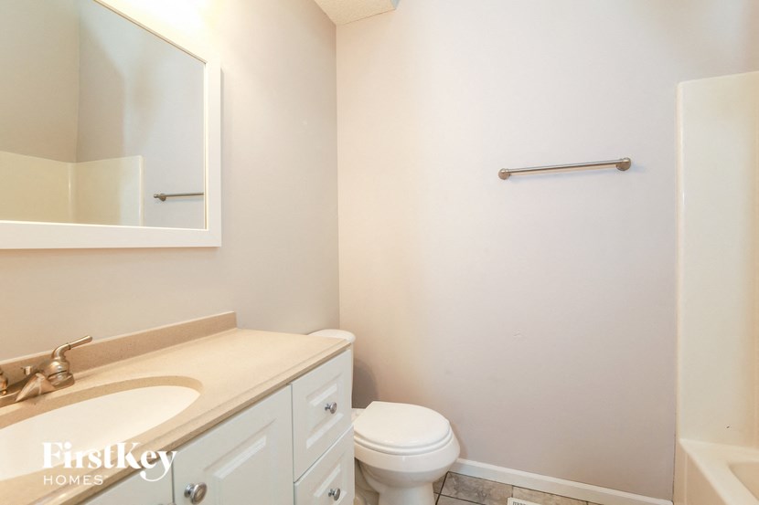 a bathroom with a toilet and a sink and a mirror