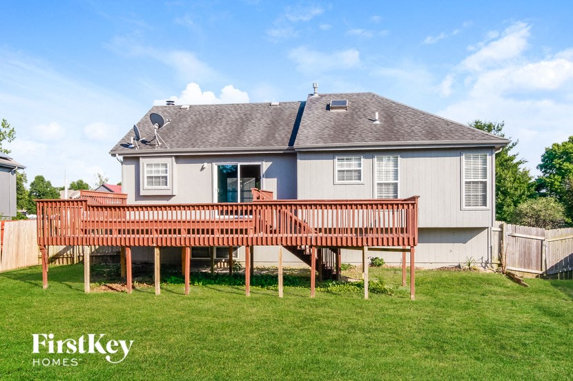 a backyard with a deck and a house
