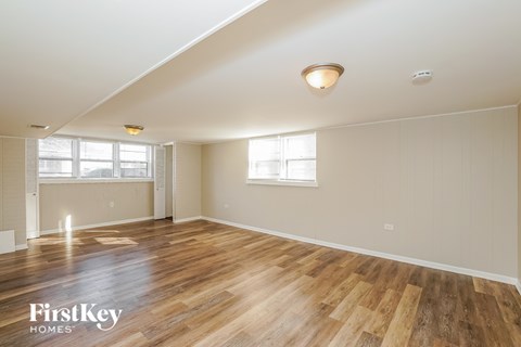 a living room with wood floors and white walls and a window