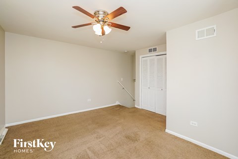 a bedroom with a ceiling fan and a closet
