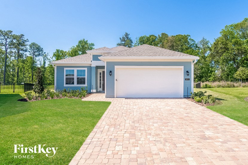 a blue house with a driveway and a garage door