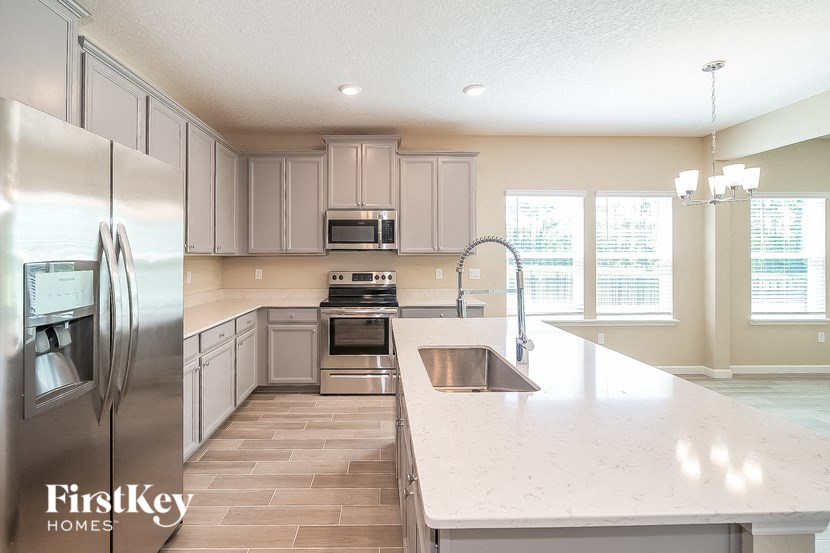 a white kitchen with stainless steel appliances and white countertops