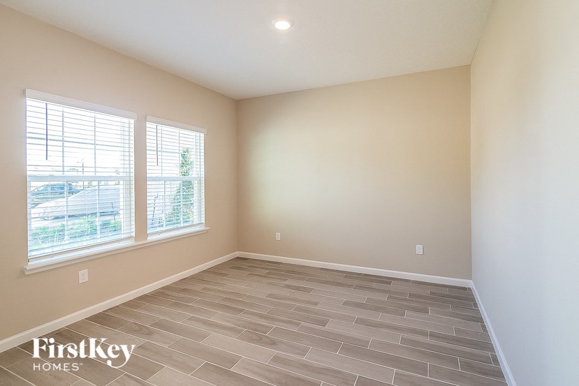 the master bedroom has a large window and a tiled floor