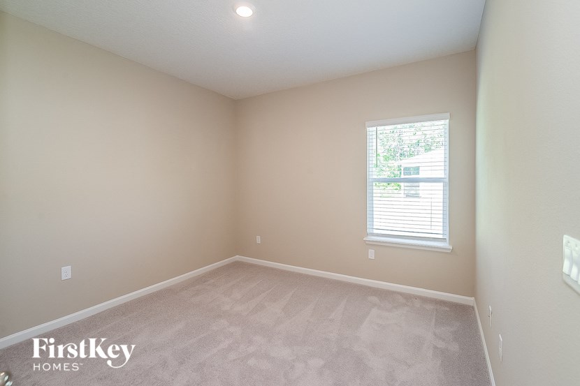 a bedroom with a carpeted floor and a window
