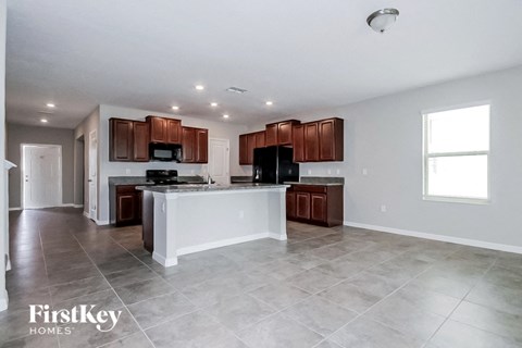 A spacious kitchen with brown cabinets and a white island.
