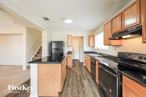 A kitchen with wooden cabinets and black appliances.