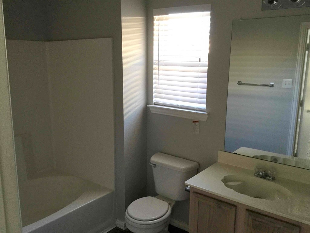 a bathroom with a toilet and a sink and a bath tub