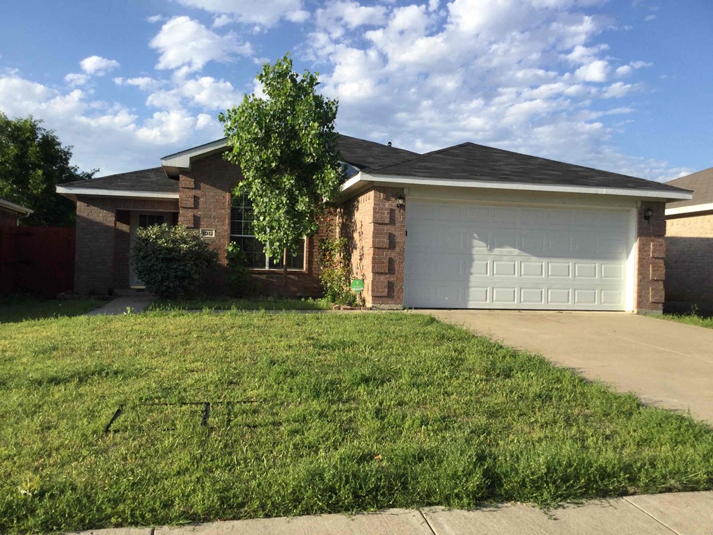 a house with a lawn and a white garage door