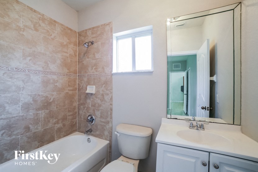 a bathroom with a toilet sink and tub and a mirror