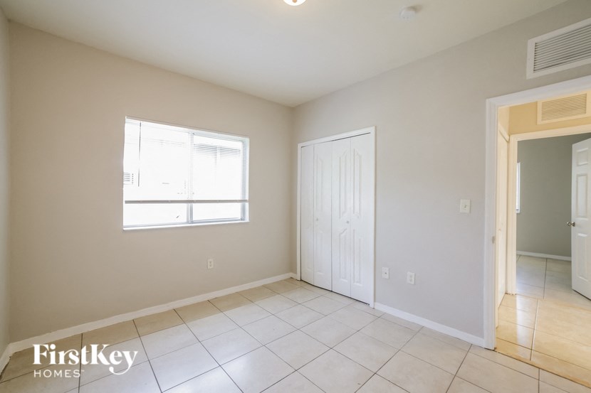 an empty living room with a white door and a window