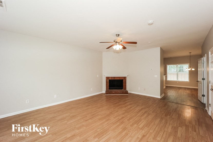a living room with a fireplace and a ceiling fan