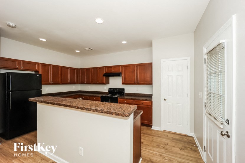 a kitchen with a counter top and a black refrigerator
