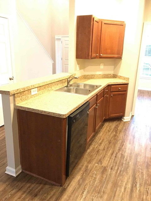 A kitchen with wooden cabinets and a granite counter top.