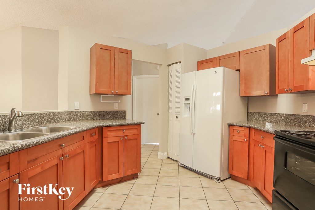 A kitchen with wooden cabinets and a white refrigerator.