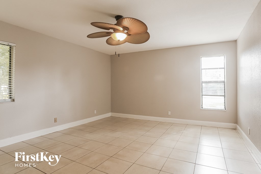 A room with a ceiling fan and tiled floor.