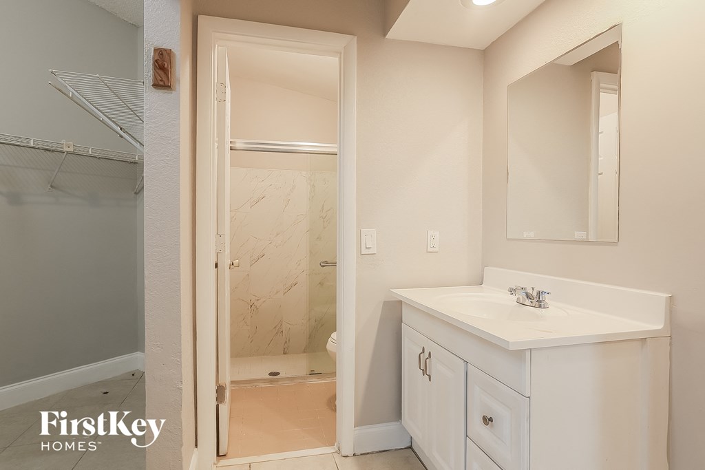 A bathroom with a white sink and a walk-in shower.