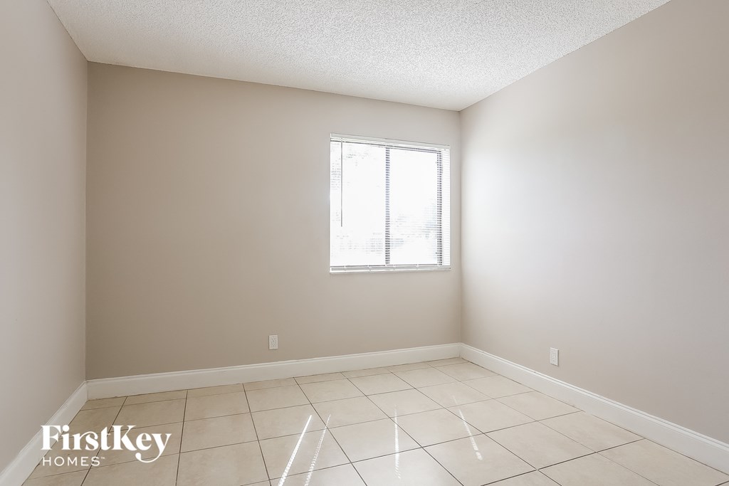 A room with a window and tiled floor.