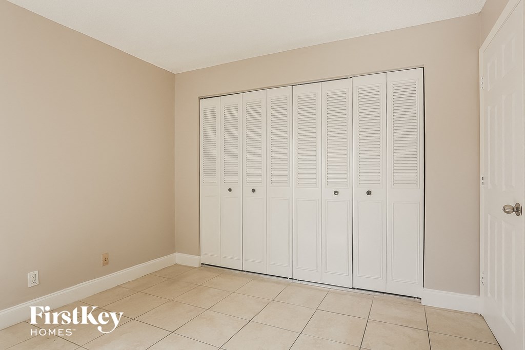 A room with a white closet and a door.
