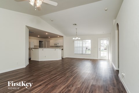 the living room and kitchen of an empty house