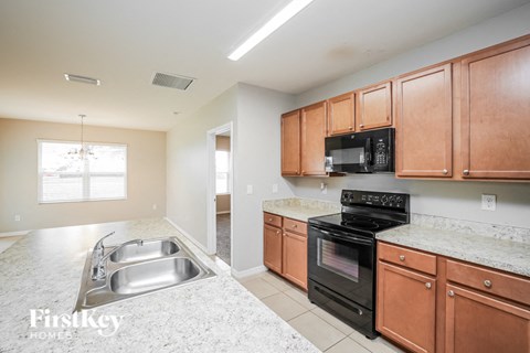 A kitchen with a black microwave and stove top oven.