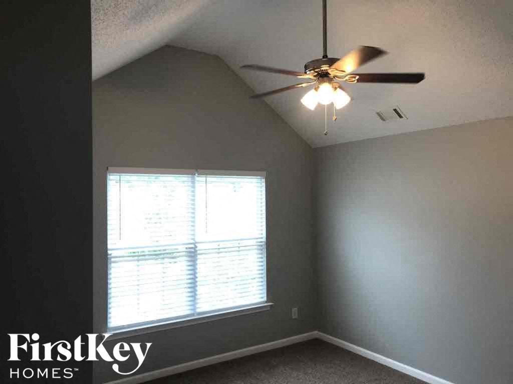 a bedroom with a ceiling fan and a window