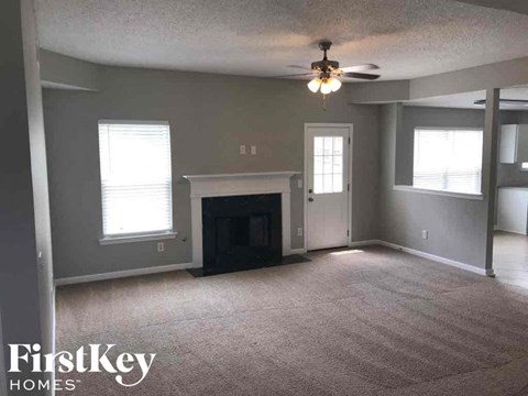 a living room with a fireplace and a ceiling fan