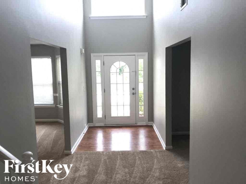 an empty room with a white door and a window
