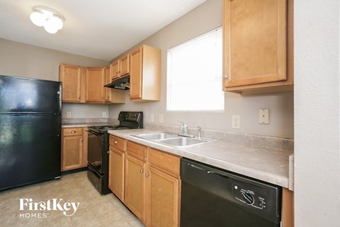 A kitchen with wooden cabinets and black appliances.