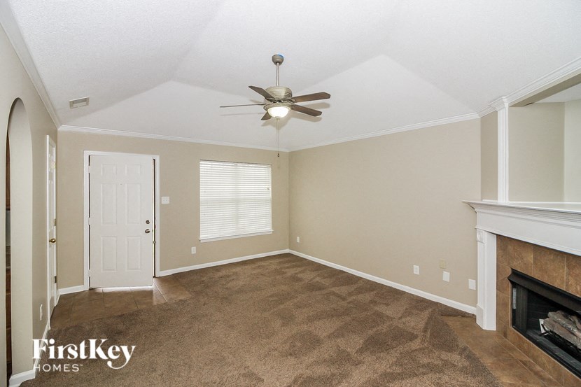 a living room with a ceiling fan and a fireplace